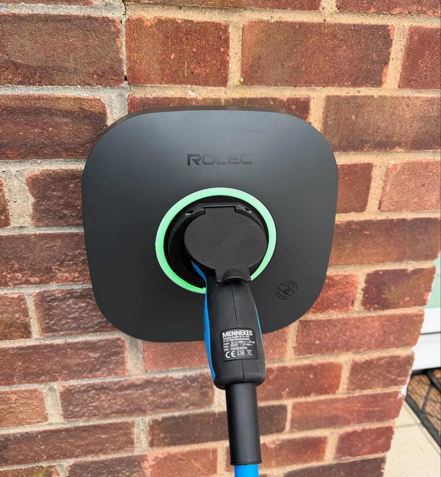 Rolec electric vehicle charger mounted on a brick wall