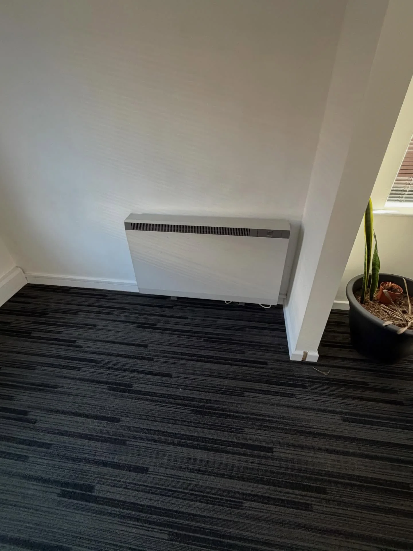 Wall-mounted electric storage heater in a finished interior