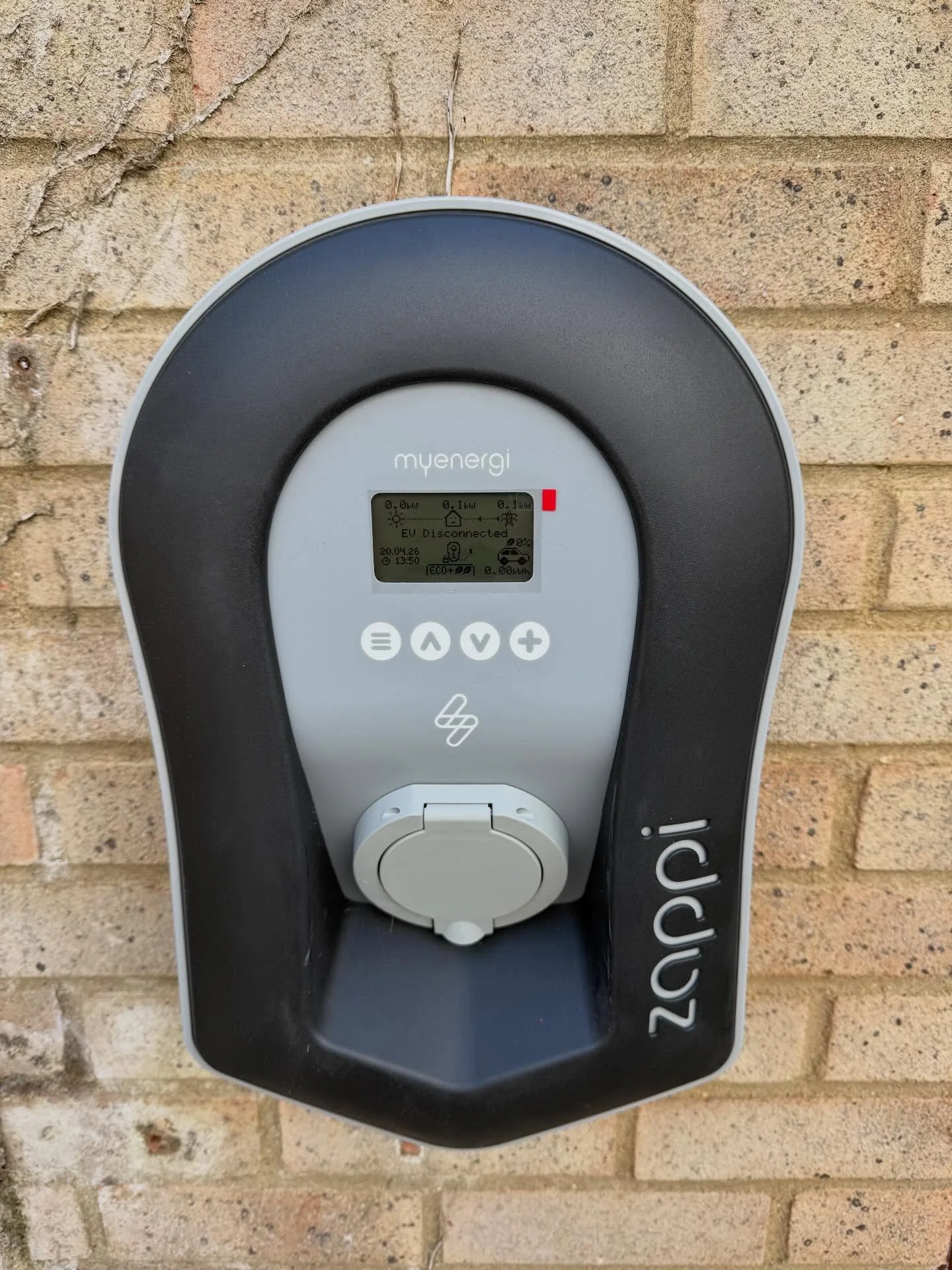 Myenergi Zappi electric vehicle charger on a brick wall