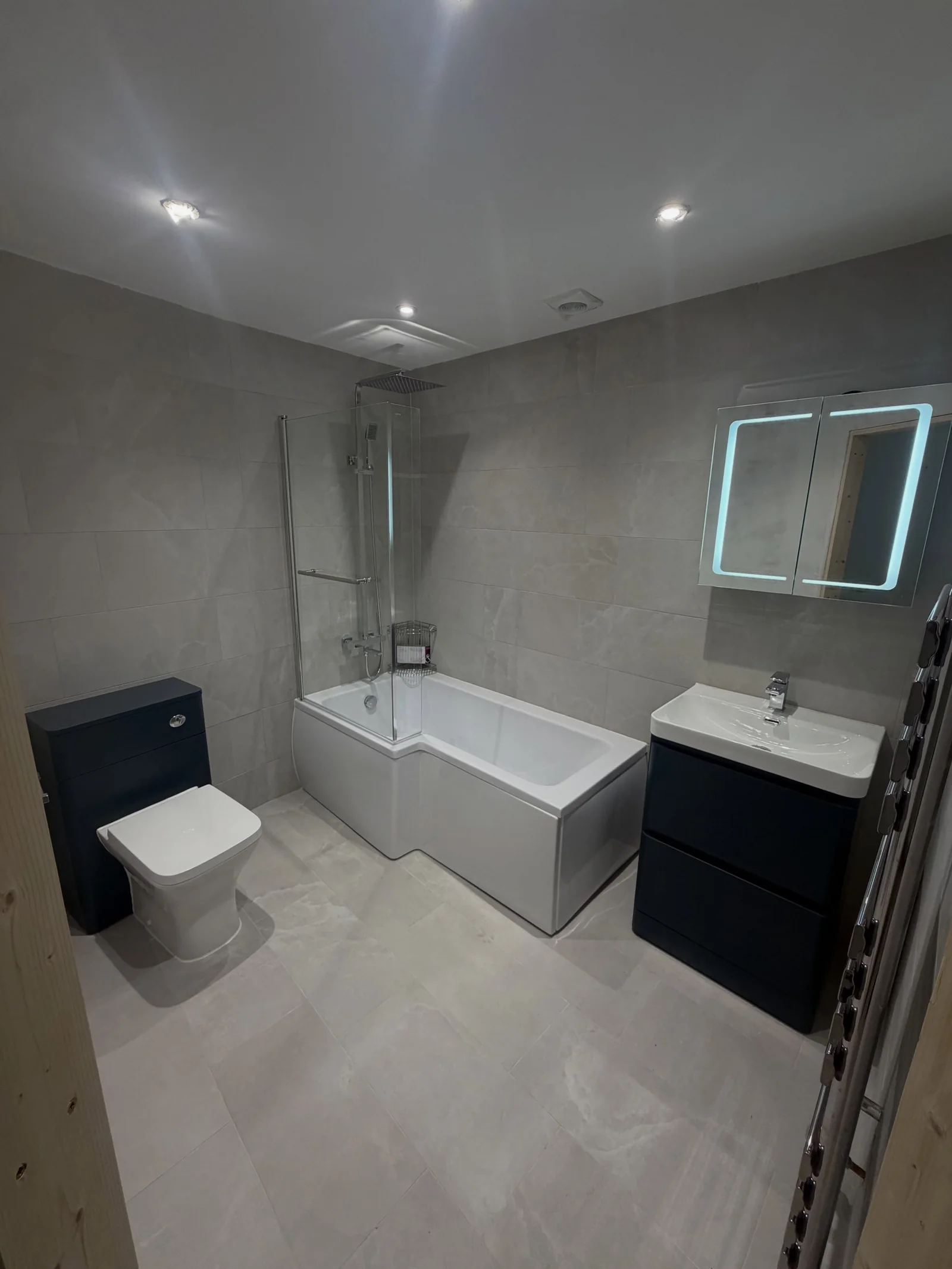 Modern bathroom with recessed lighting and an illuminated mirror